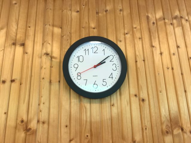 Clock On Wood Panel Wall Showing The Current Time