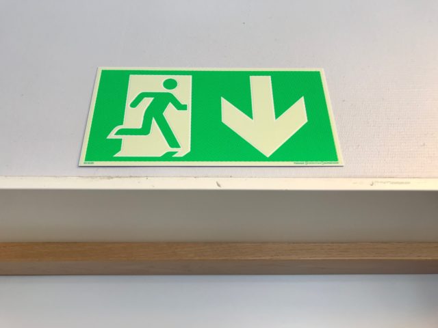 Green Emergency Exit Sign Over A Door