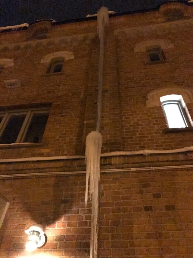 Huge Icicles Hanging From Roof On Old House