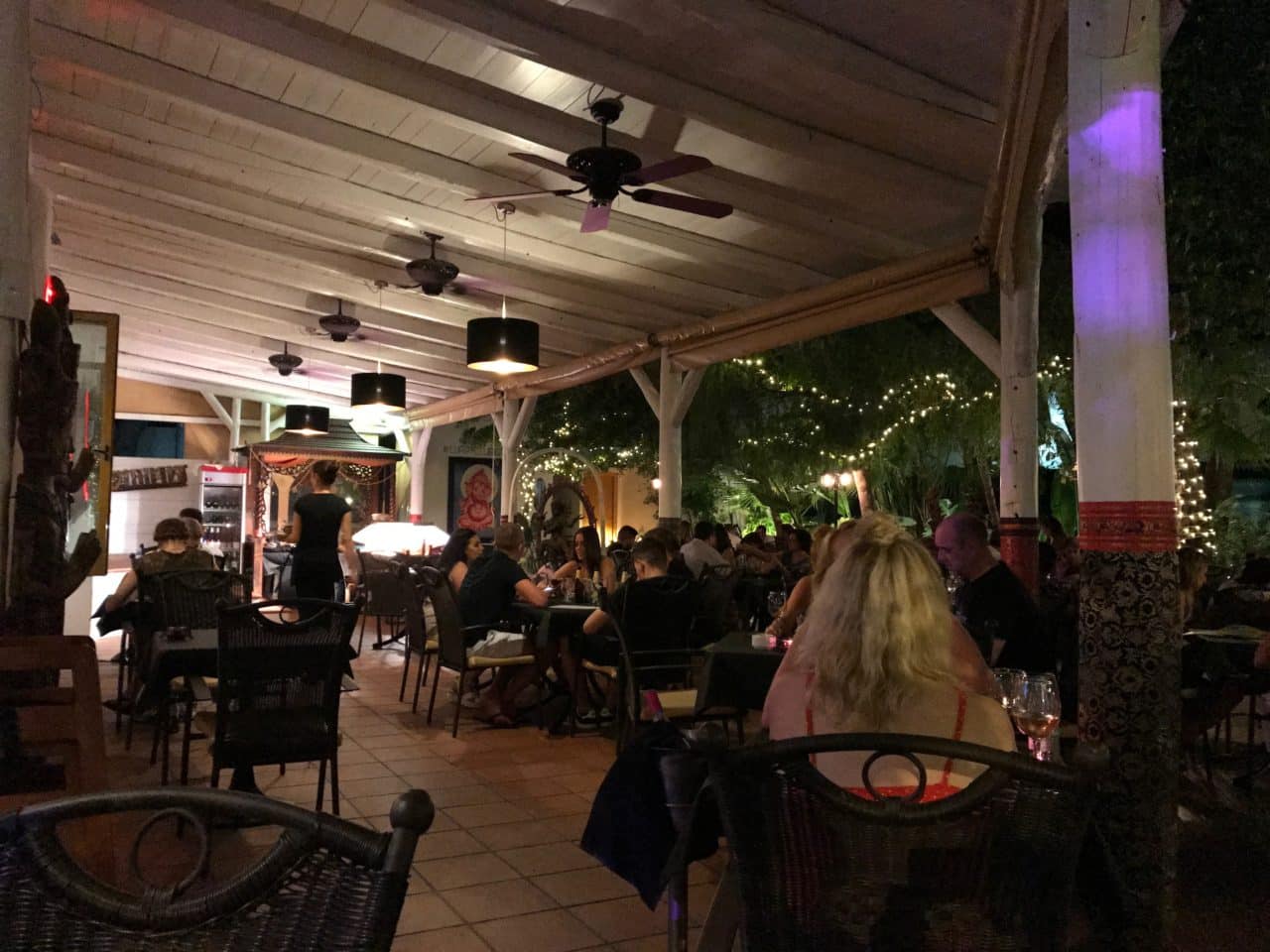 People Sitting In A Restaurant Eating With Fans And Lights