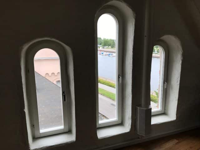 Three Windows Overlooking River With Boats