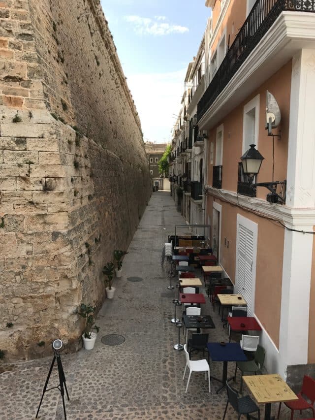 Narrow Street Restaurant With Tables And Chairs