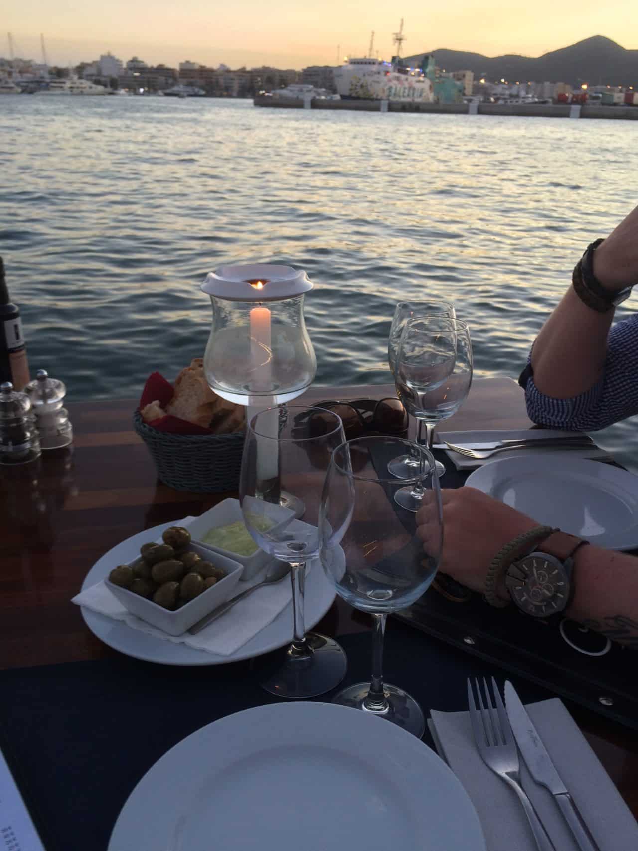 Romantic Dinner By The Sea With Candles And Olives And Aioli And Bread On Brown Table