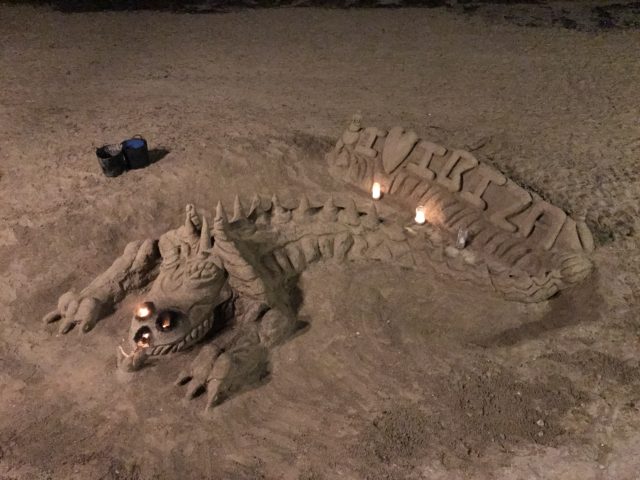 Dragon Sand Sculpture On The Beach With Candles