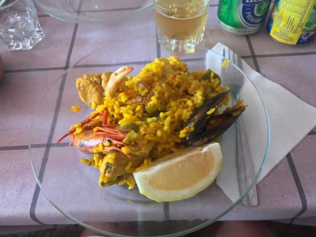 Glass Plate Of Paella With Shrimp And A Lemon