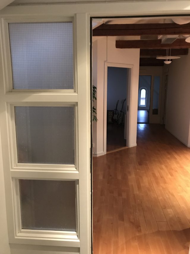Open Door To Dark Hallway With Wooden Beams In Ceiling