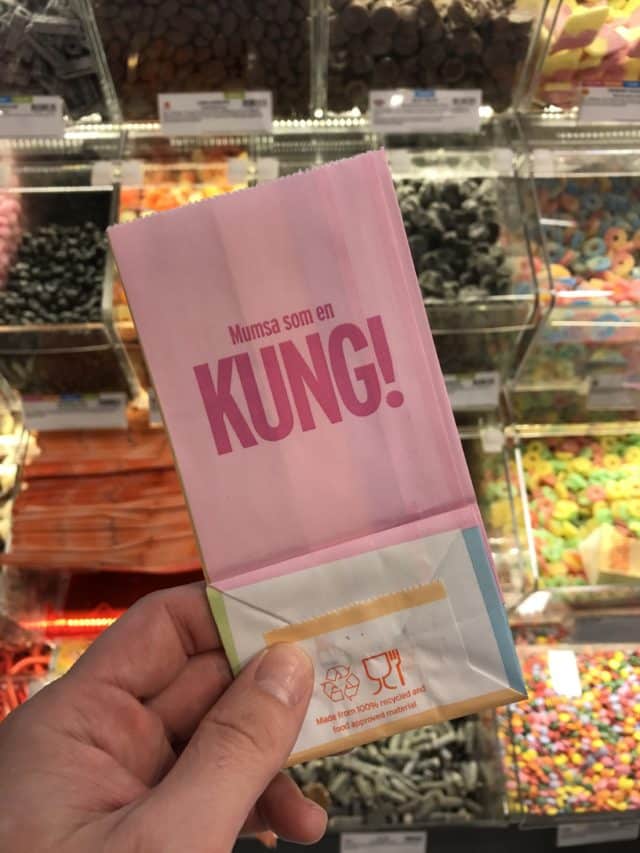 Pink Paper Candy Bag With Candy In The Background