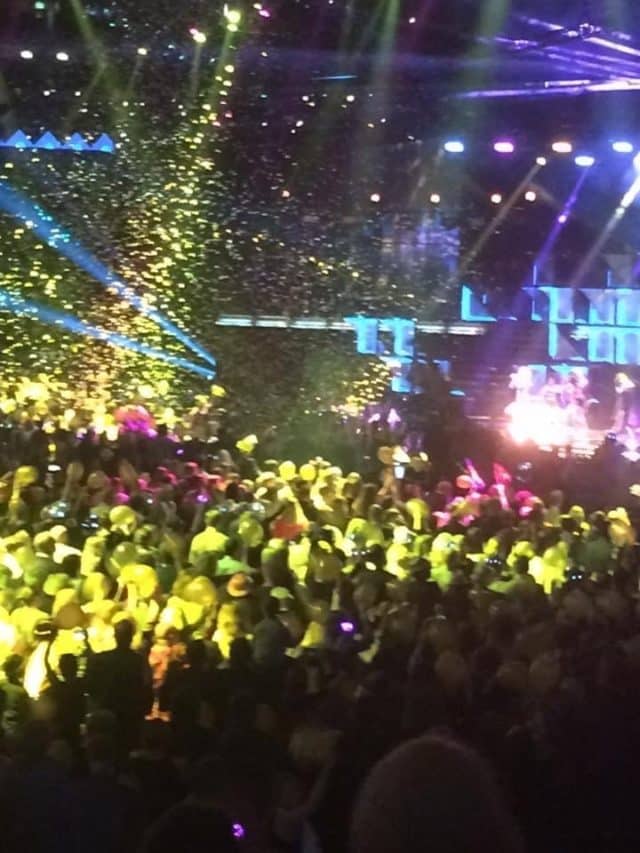 Concert With Headlights In Different Colors And Gold Confetti In Air
