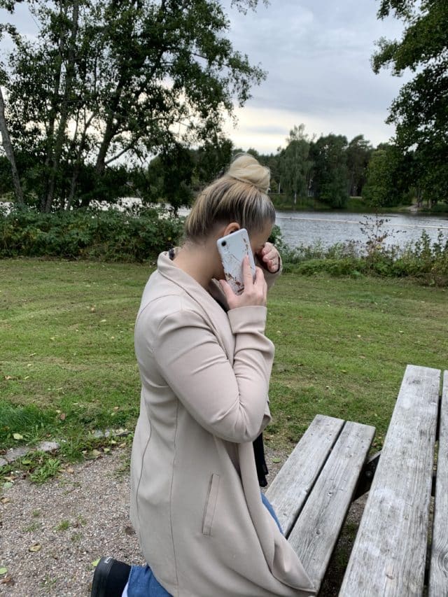 Woman With Her Hand Over Her Face Talking On Phone