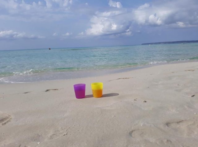 Chill And Wine In Plastic Mugs On White Sandy Beach In Spain