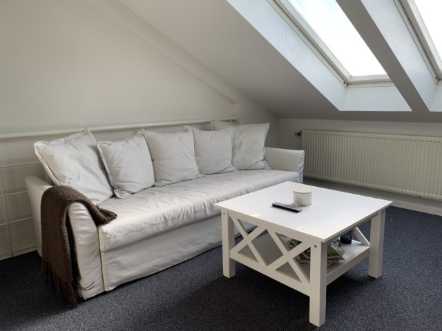 White Couch And Table In A Lounge With Skylight Windows