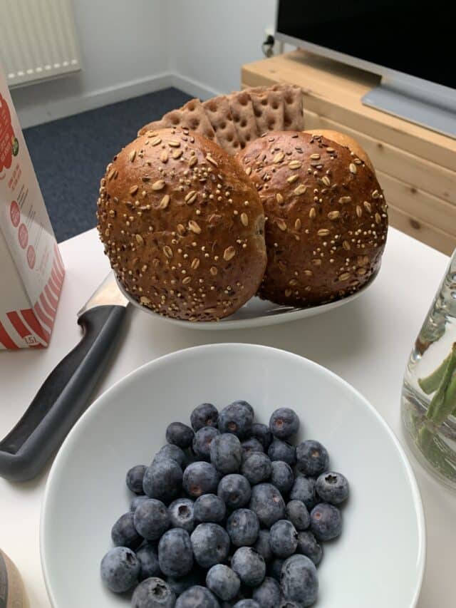 Bowl Of Blueberries And A Plate With Wholegrain Bread And A Carton Of Milk