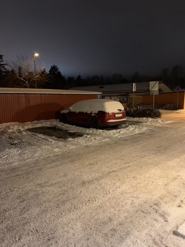 Red Ford Focus Covered In Snow In Parking Lot In Winter
