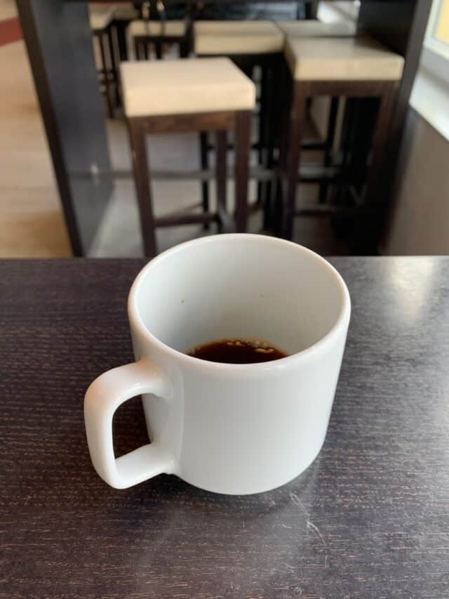 Half Full Cup Of Coffee On Table At Café
