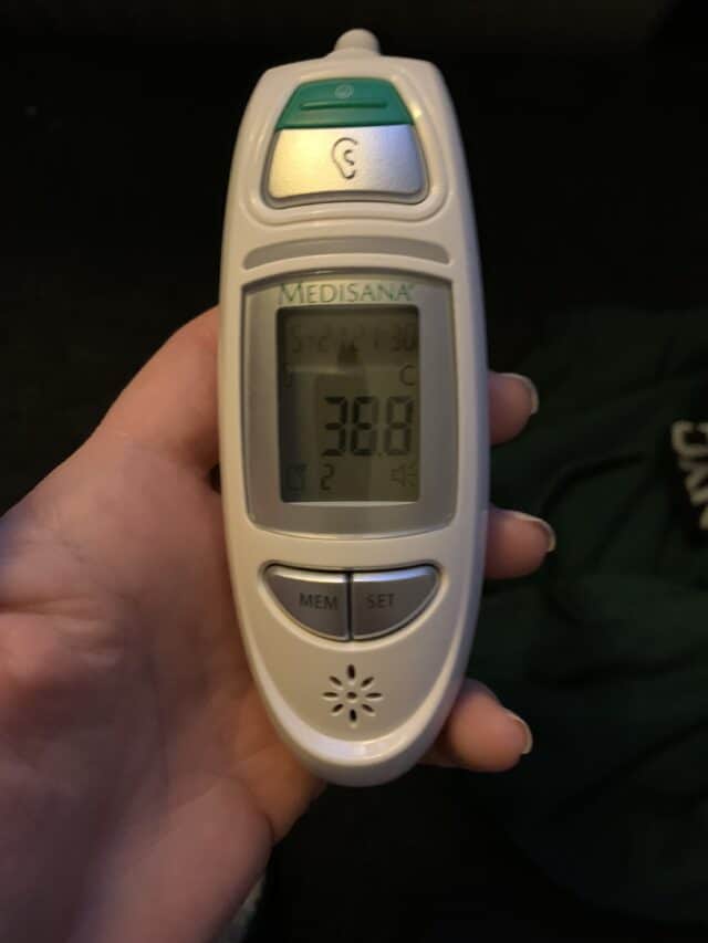 Hand Holding Digital Thermometer Showing Temperature