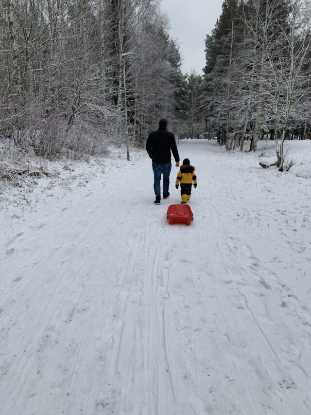 Father And Son Walking On Path In The Snow In Winter