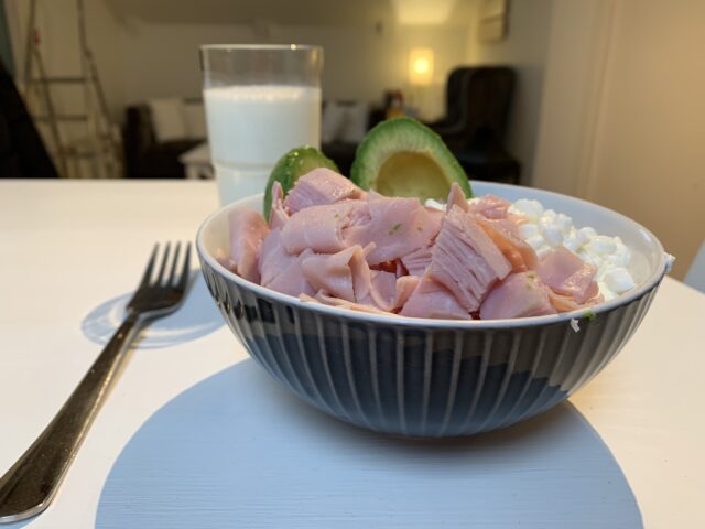 Bowl Of Ham Cottage Cheese And Avocado With A Glass Of Milk And A Fork