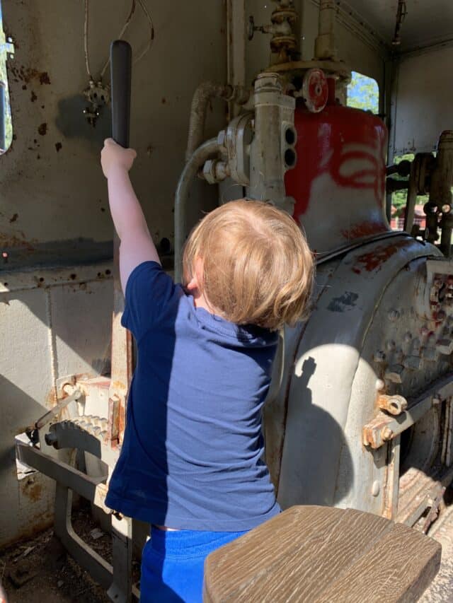 Child Pulling Lever In Old Train Locomotive