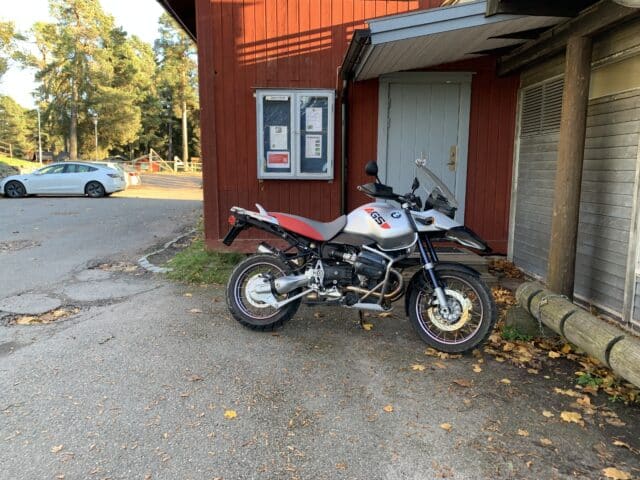 Motorcycle And Car Parked In Front Of House