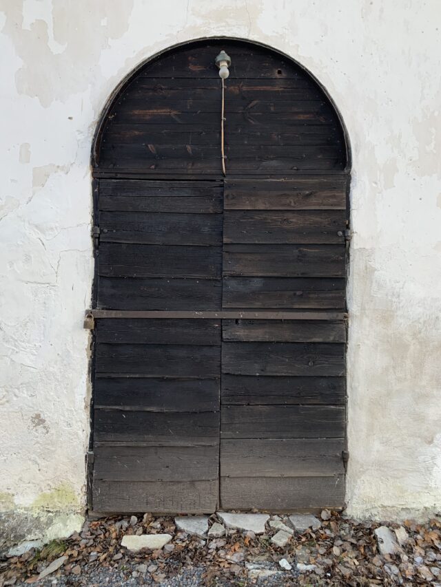 Old Wooden Door To A White Church