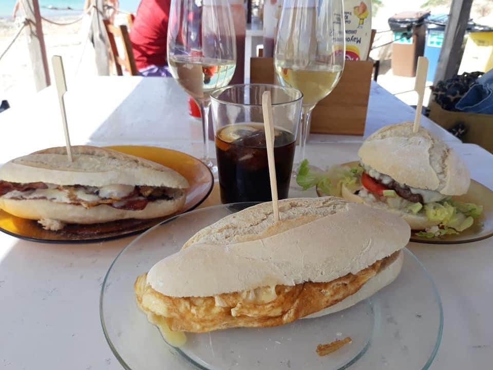 Sandwiches And Hamburgers On A Beach Restaurant With Wine Glasses