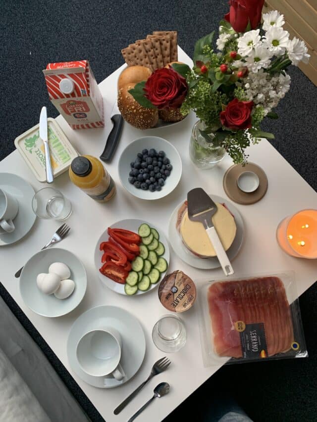 Breakfast Table With Cheese Juice Milk Bread Berries Eggs And Flowers