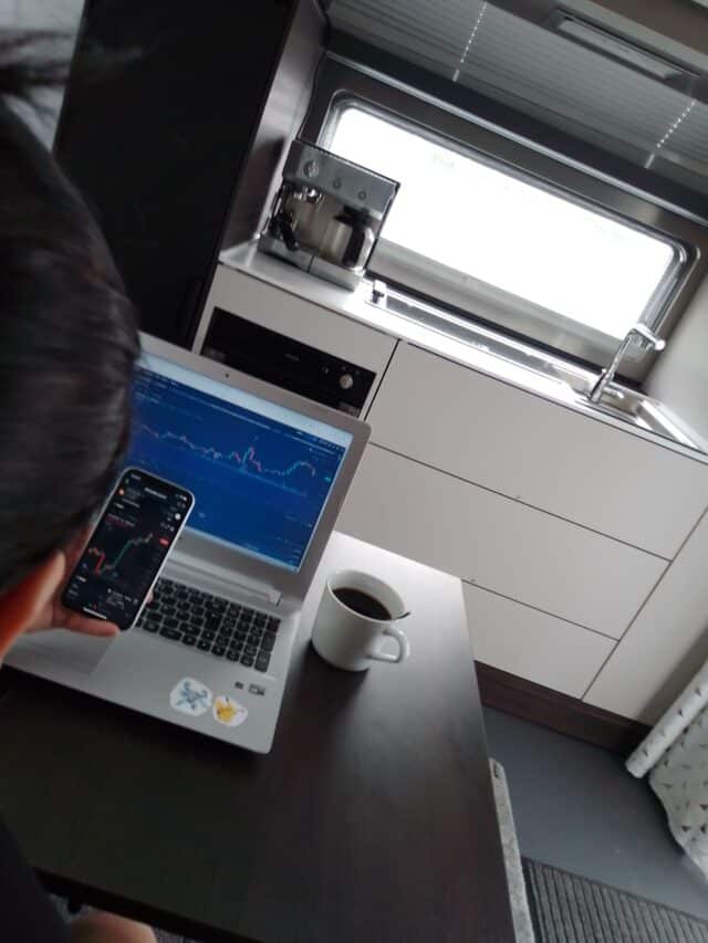 Person Using Phone And Laptop When Trading Crypto