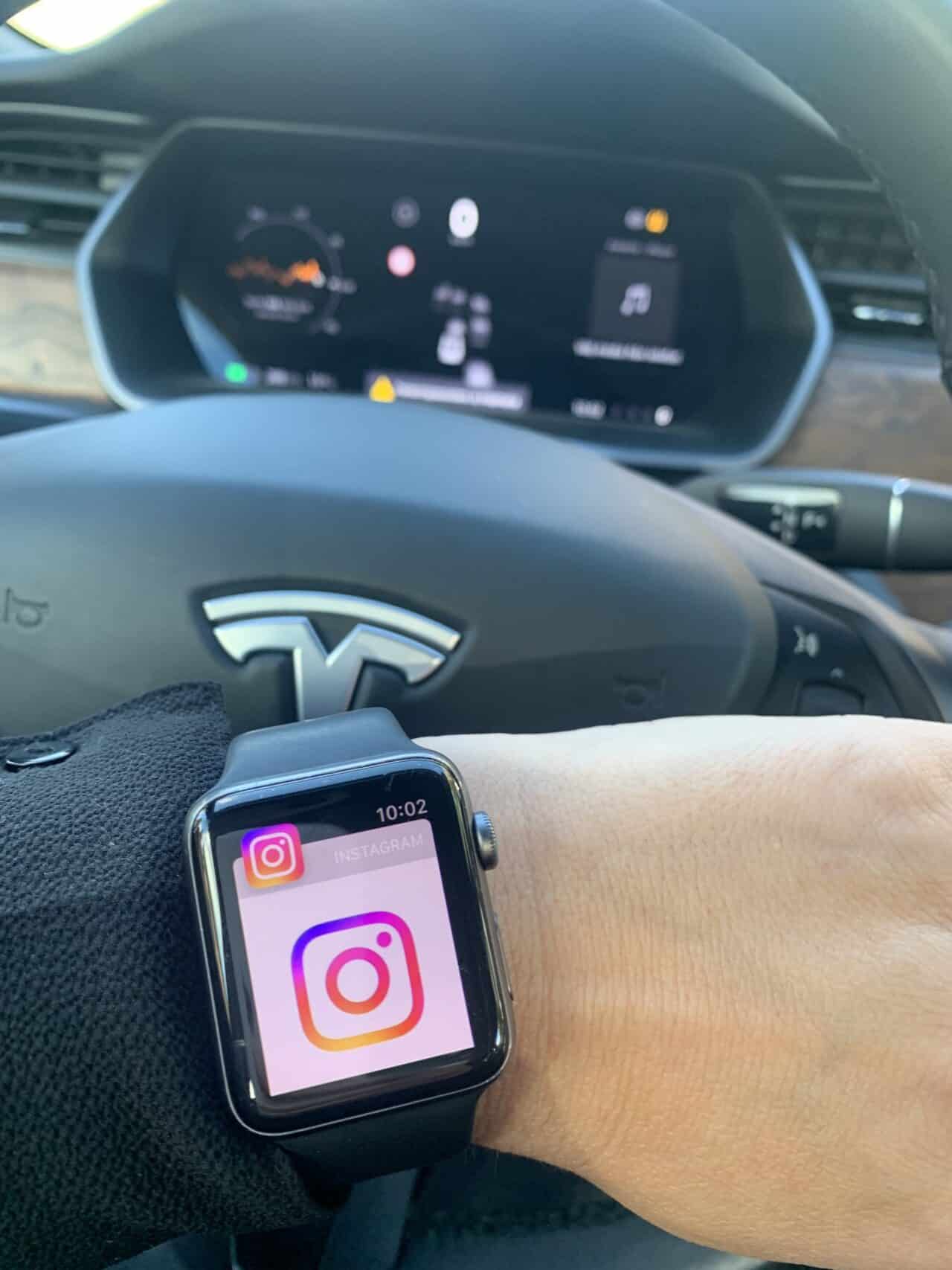 Woman Looking At Instagram On Smartwatch In Tesla Car